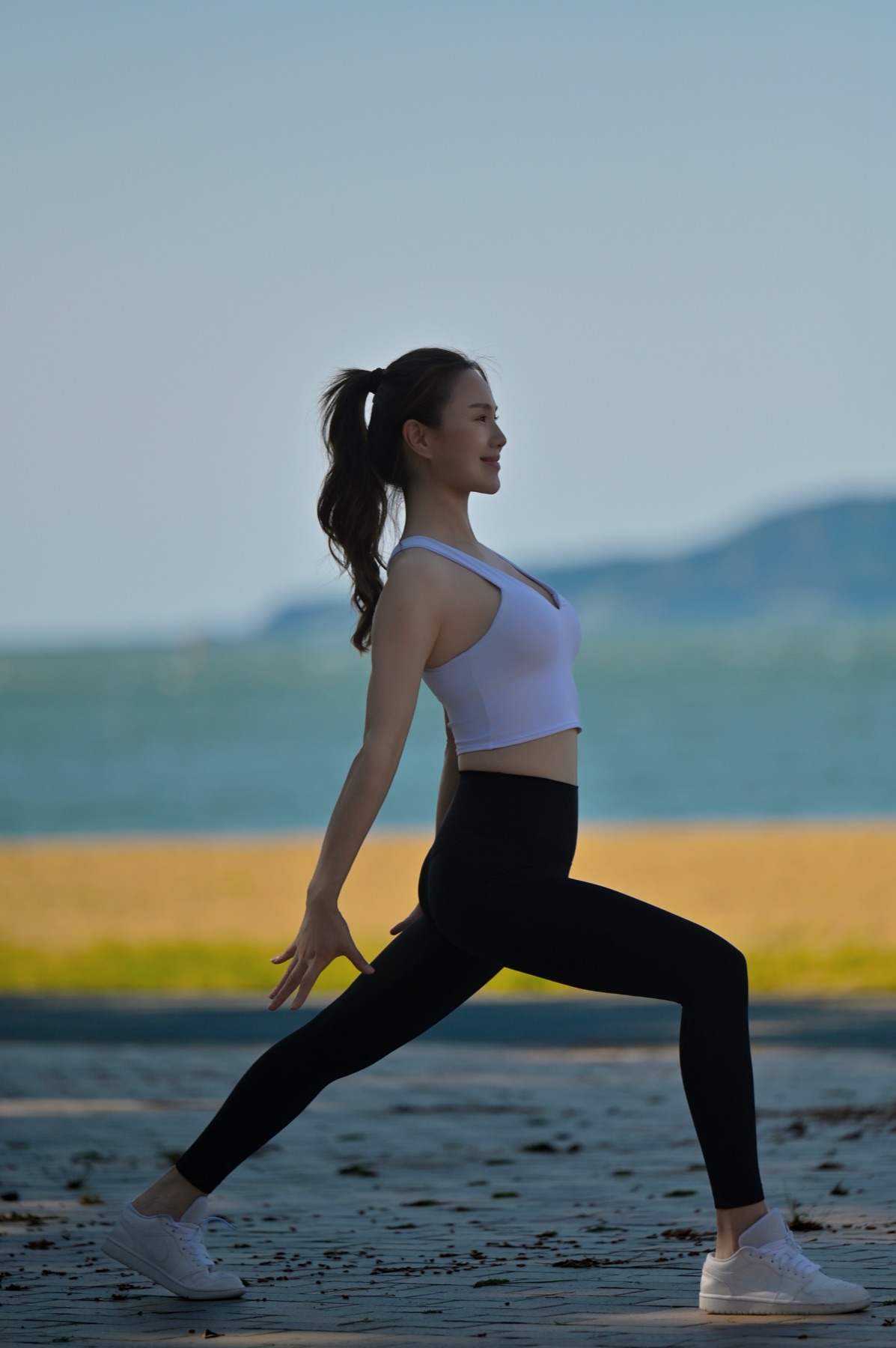 海辺でストレッチをするトレーナー