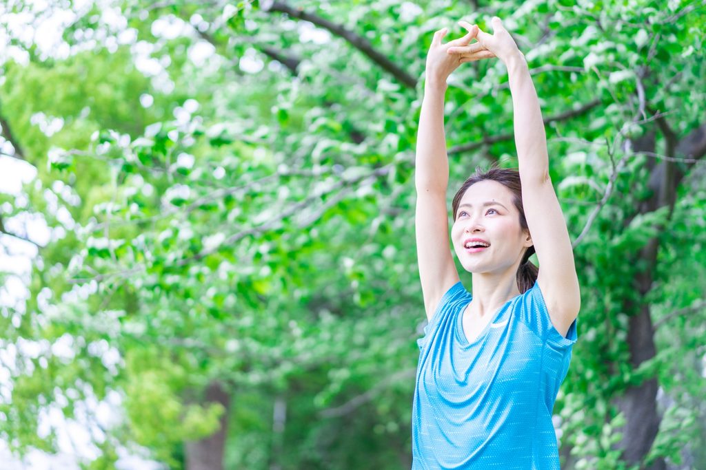 自然の中でストレッチをする女性